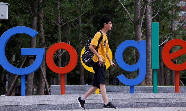 A man walks past the brand logo of Alphabet Inc's Google outside its office in Beijing