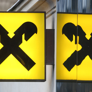 The logo of Raiffeisen Bank International is reflected in the glass of a branch office in Vienna