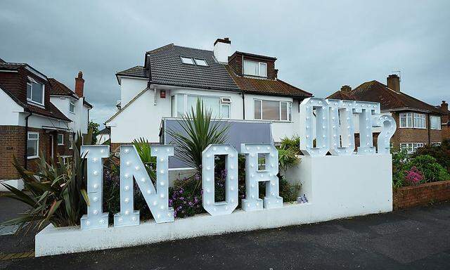 "Rein oder raus", heißt es vor einem Haus in Großbritannien.