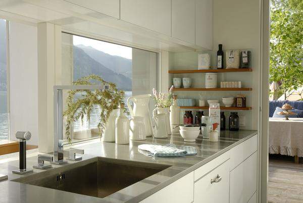 Auch von innen, hier die Küche - ganz in weiß gehalten - war der Blick auf den Zeller See ein wichtiges Gestaltungselement.