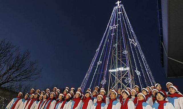 South Korean Christians sing a hymn in front of a Christmas tree on top of the Aegibong Peak Observat