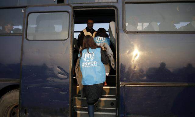 UNHCR-Mitarbeiter bringen Flüchtlinge in das Lager Moria auf Lesbos. Die Transfers will die Organisation nun einstellen.