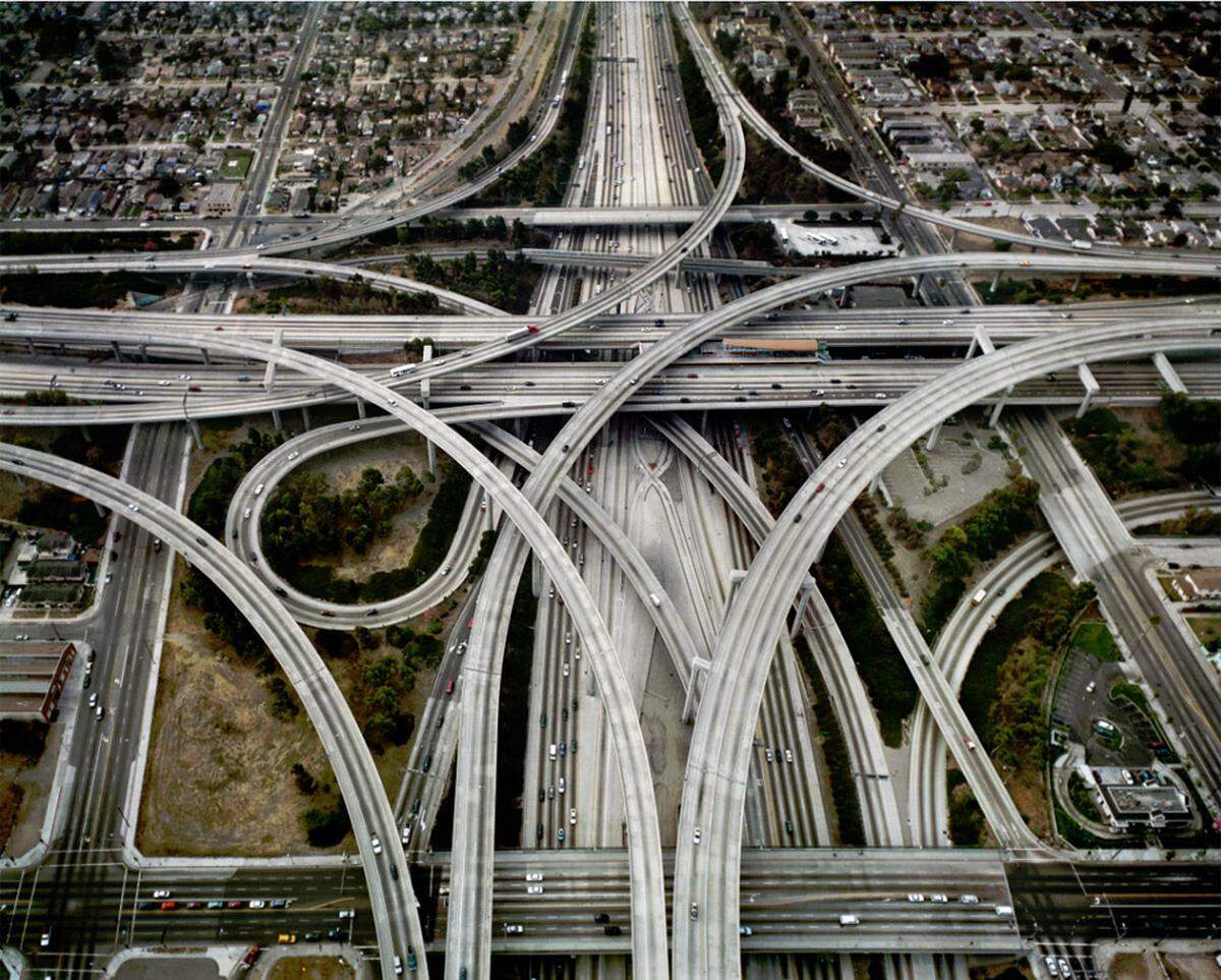 Burtynsky dokumentiert auch, was der Mensch alles mit Hilfe des Öls macht und wie sehr das die Landschaften verändert. "Transportation &amp; Motor Culture" zeigt mehrspurige Highways mit gordischen Verkehrsknoten, ...Highway #1 . Intersection 105 &amp; 110 . Los Angeles, California USA . 2003