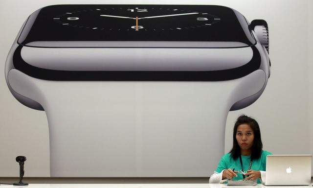 File photo of a sales assistant working in front of an advertisement for the Apple watch at an Apple reseller shop in Bangkok