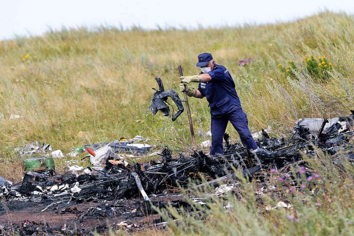Ukrainische Arbeiter inspizieren die Überreste des Fluges MH17. Drei Tage zuvor wird das Passagierflugzeug der Malaysia Airlines mit 298 Menschen an Bord über der Ostukraine abgeschossen, alle Insassen sterben.