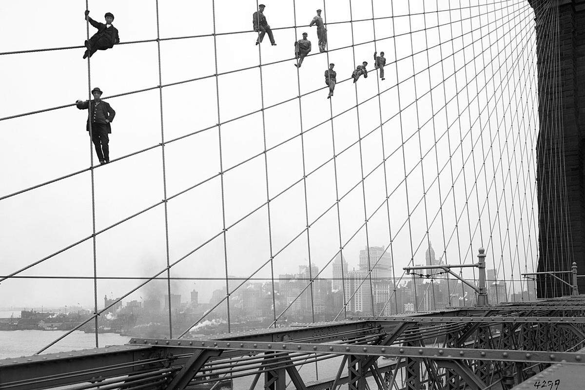 Die meisten der Bilder wurden von anonymen Gemeindemitarbeitern aufgenommen. Von einigen Aufnahmen sind die Urheber jedoch bekannt. Diese Fotos machte Eugene de Salignac, ein Mitarbeiter der für Brücken zuständigen Abteilung der Stadt. Arbeiter hängen in den Seilen der Brooklyn Bridge. Das Foto stammt vom 7. Oktober 1914.