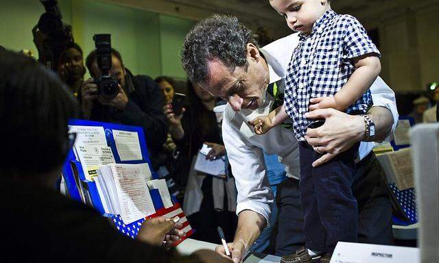 New York City Democratic mayoral candidate Weiner  prepares to cast his vote in a polling center with his son, Jordan, during the primary election in New York