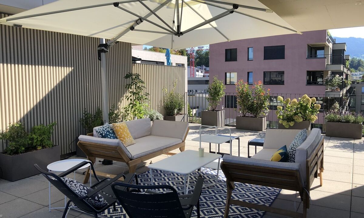 Wohnzimmer im Freien mit Teppich und Couchtisch