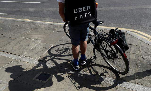 FILE PHOTO: A cyclist prepares to delivery an Uber Eats food order in London