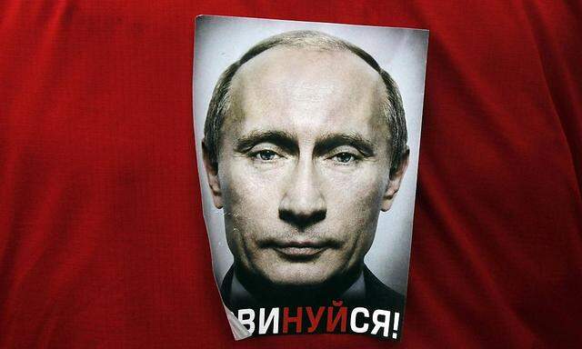 Ein Bild auf einer Anti-Putin-Demonstration in Moskau. Unter dem Portrait des Präsidenten steht in russicher Schrift 