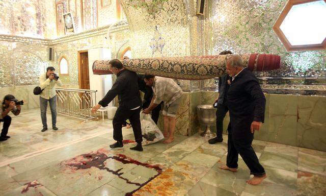 Arbeiter säubern den Tatort nach einem bewaffneten Angriff auf das Shah Cheragh-Mausoleum in der iranischen Stadt Shiraz am 26. Oktober 2022.
