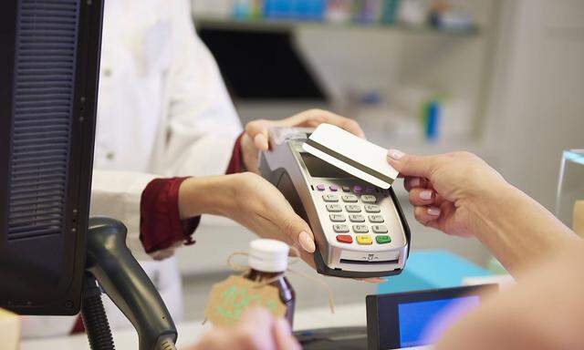 Customer paying cashless with credit card in a pharmacy model released Symbolfoto property released