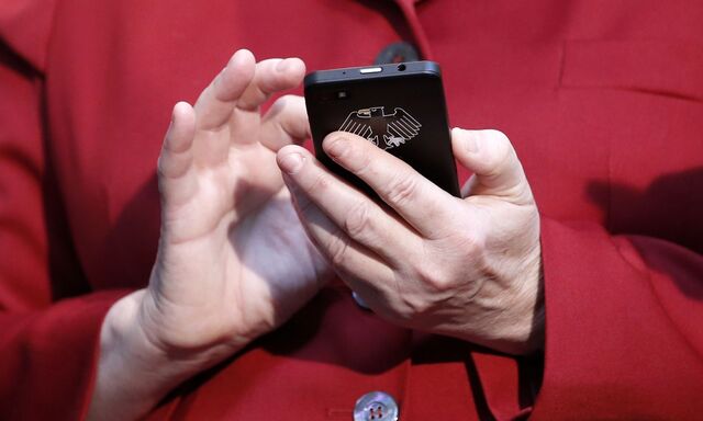 Merkel hält ein Smartphone in Händen