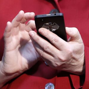 Merkel hält ein Smartphone in Händen