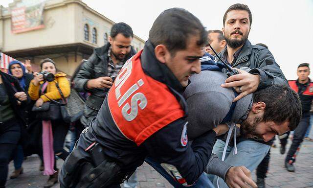 Türkische Polizisten inhaftieren einen kurdischen Demonstranten.