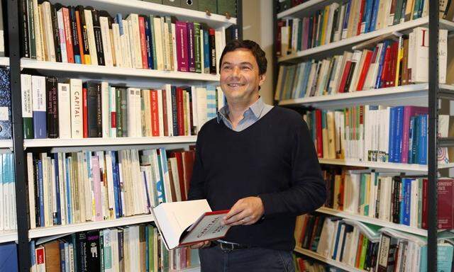 Thomas Piketty, French economist and academic, poses in his book-lined office at the French School for Advanced Studies in the Social Sciences (EHESS), in Paris