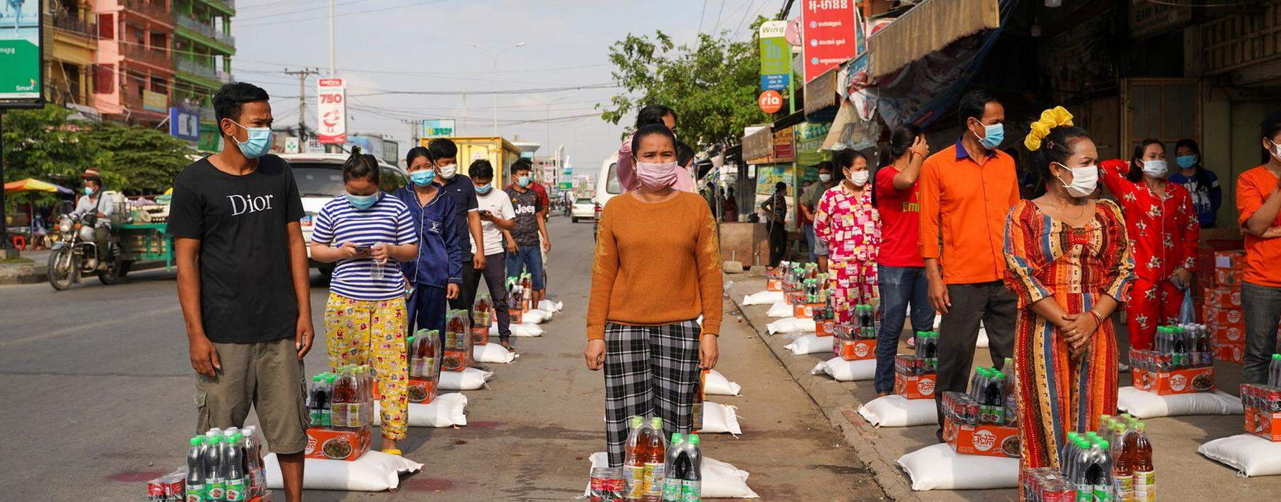 Rote Zone in der Hauptstadt Phnom Penh: Arbeiter warten diszipliniert auf die Verteilung von Lebensmitteln.