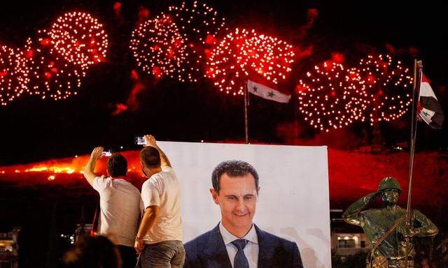 Supporters of Syria´s President Bashar al-Assad celebrate after the results of the presidential election announced that he won a fourth term in office, in Damascus