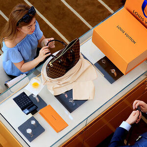 A woman buys a Louis Vuitton bag in a shop in Singapore