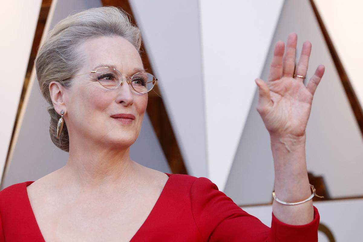 Meryl Streep trägt Kostbarkeiten von Fred Leighton: Die goldenen pfeilförmigen Ohrringe bestehen unter anderem aus einem alten Bergdiamanten. Ihr Armreif glänzt in Gold.
