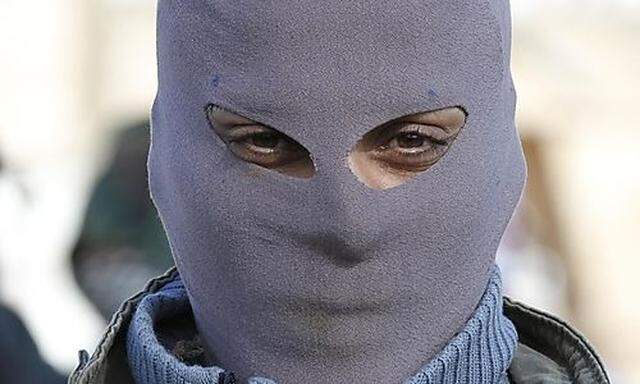 A masked Syrian rebel attends a demonstration in Idlib, Syria, Friday, Feb. 10, 2012. (AP Photo)