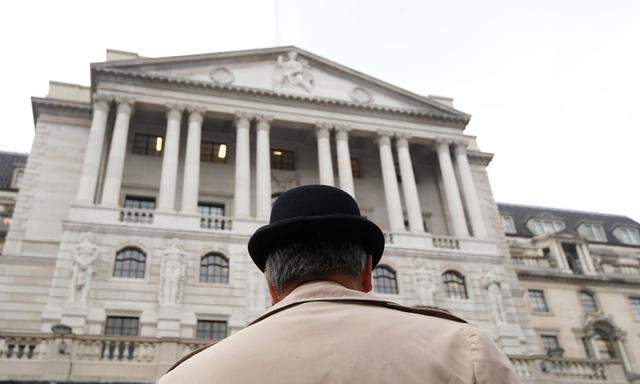 A man wears a bowler hat outside the Bank of England in the City of London