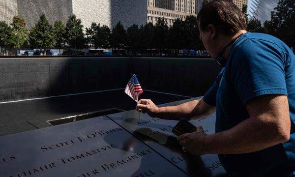 Ein Mann hinterlässt beim 9/11-Mahnmal in New York eine kleine US-Flagge