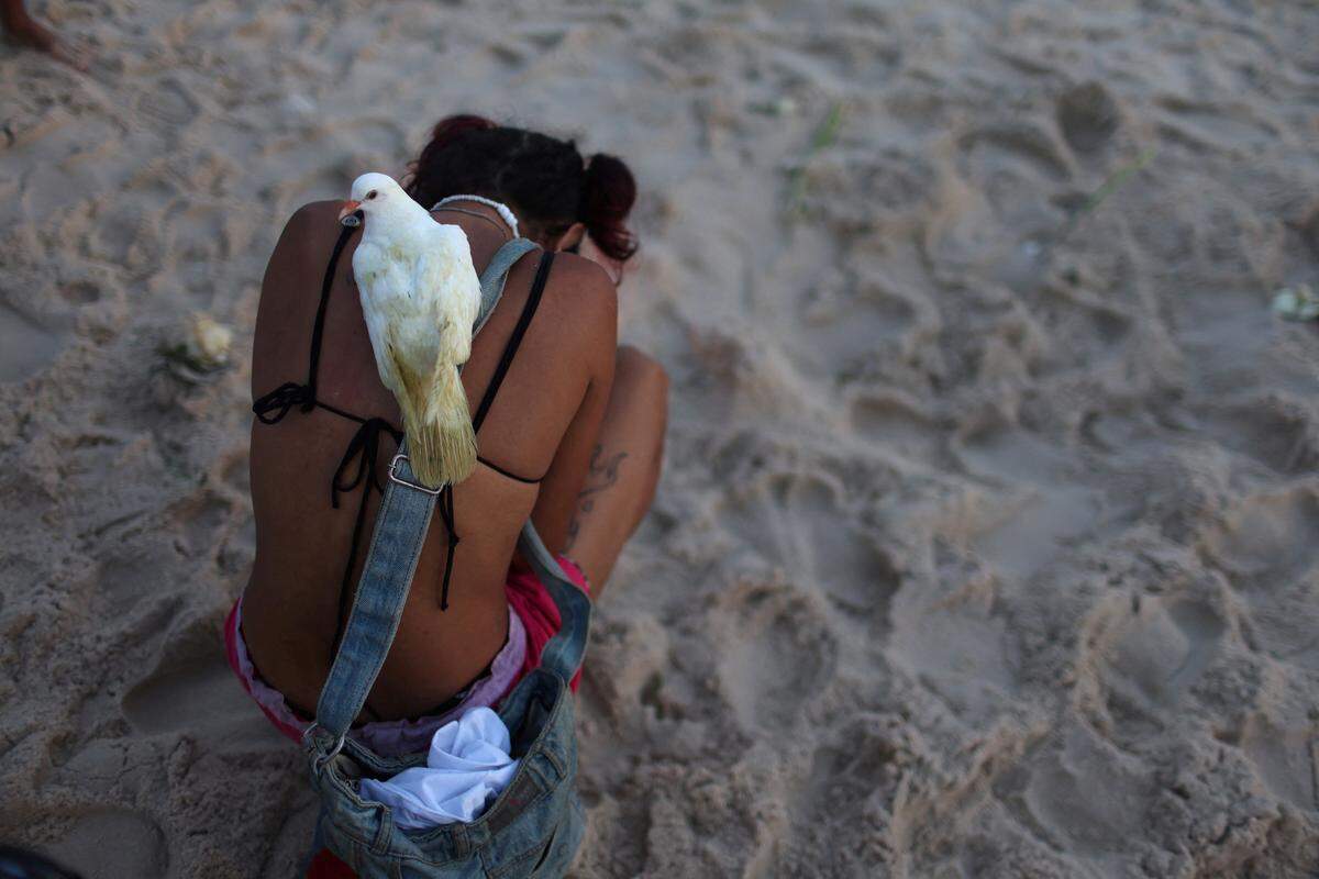 29. Dezember. Eine traditionelle Jahreswechselzeremonie am Strand von Rio de Janeiro: Eine Frau zollt der Göttin des Meeres, Yemanja, Tribut. 