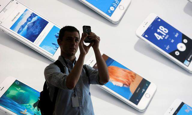 FILE PHOTO: A man uses his iPhone during a preview event at the new Apple Store Williamsburg in Brooklyn, New York