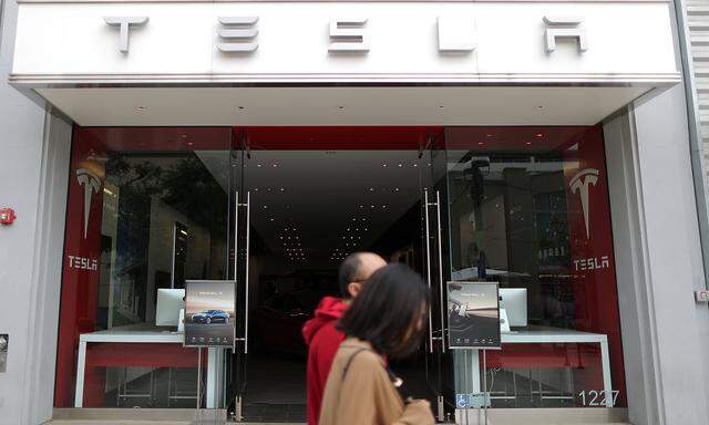 People walk past a Tesla showroom in Santa Monica