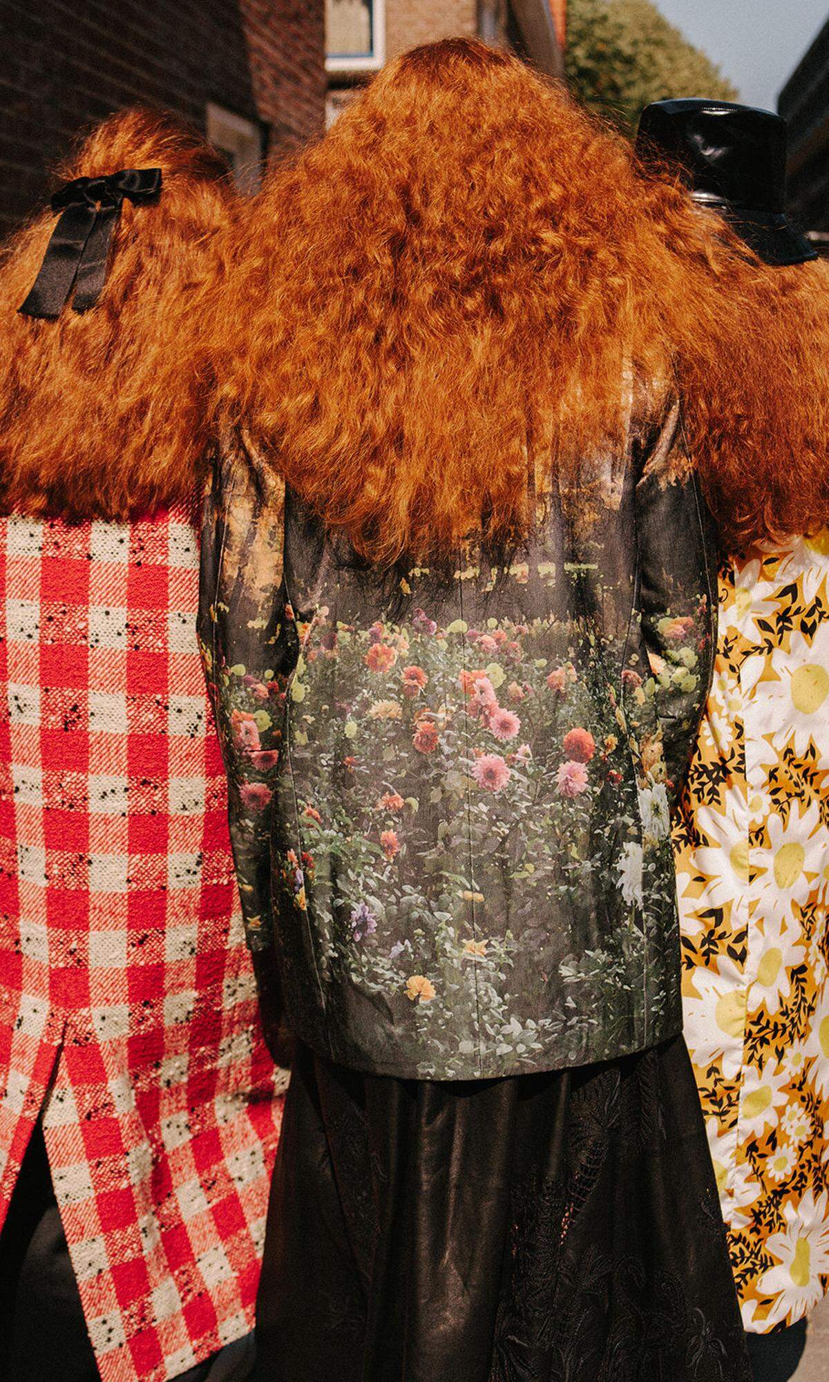 Von links: Mantel von Marni, Haarschleife von Chanel. Jacke mit Blumenprint von Bevza, Lederrock von Dior. Daunenmantel von Moncler x ­Richard Quinn, Bucket-Hat von Dior.