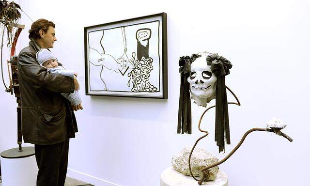 Visitors look at artists creations on the eve of the opening of the International Contemporary Art Fair in Paris