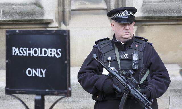 An armed police officer stands on duty outside St Stephen´s entrance to the Houses of Parliement, in London