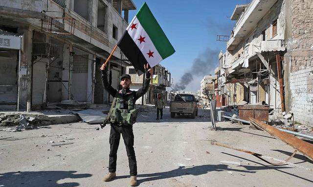 Ein von der Türkei unterstützter syrischer Kämpfer feiert die Einnahme der Stadt Saraqeb.