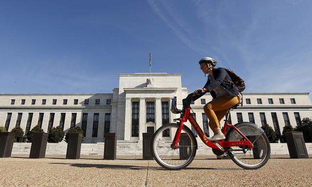 Cyclist passes the Federal Reserve in Washington