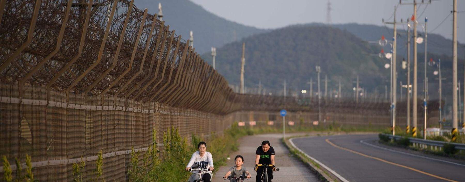 Die gefährlichste Grenze der Welt: Eine südkoreanische Familie fährt Fahrrad entlang eines Stacheldrahtzaunes der demilitarisierten Zone (DMZ), die seit 1953 Südkorea vom kommunistischen Norden trennt.