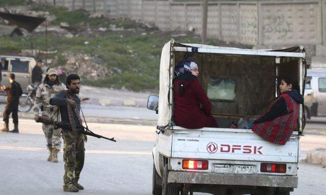 Women sit on back of pick-up truck as they stop on Shamiya Front fighters checkpoint in Al-Ansari neighborhood of Aleppo