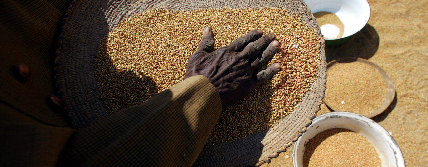 Eine Sudanesin filtert importierte Getreidekörner für die weitere Verarbeitung.