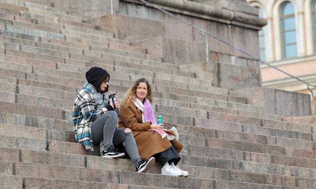 Alltag in Finnland. Zwei Frauen auf den Stufen vor der Kathedrale in Helsinki.