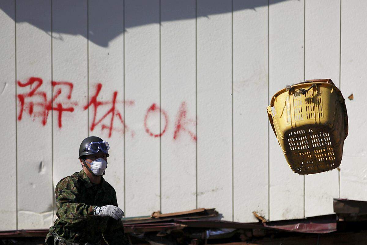 Ein Soldat wirft in Miyako letzte Gegenstände aus einem Haus, bevor dieses komplett abgerissen wird. (1. April)