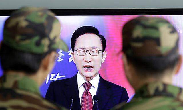 South Korean soldiers watch a live TV reporting South Korean President Lee Myung-bak speaks to the na