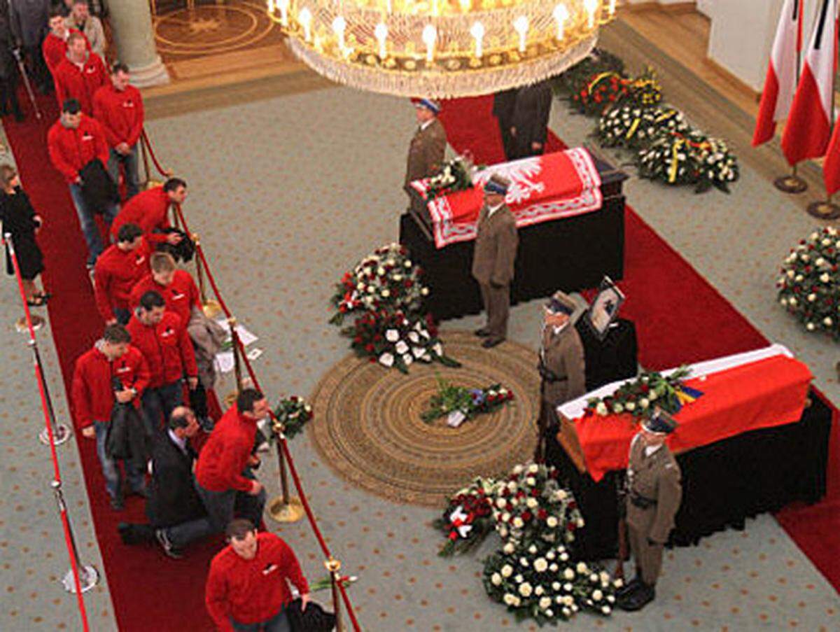 Viele Trauerende knien kurz nieder, und legen Blumen vor die Särge. Der Amtssitz des Präsidenten soll für die Besucher bis zum Wochenende zugänglich sein.