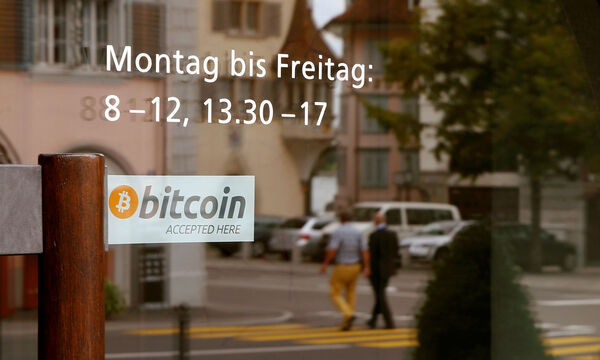 A sticker reading 'Bitcoin accepted here' is displayed at the entrance of the Stadthaus town hall in Zug