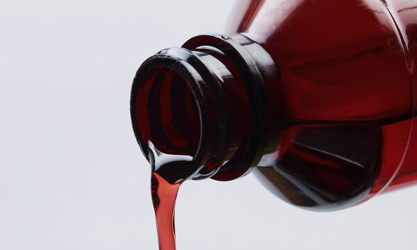 Cough Syrup Pouring into Spoon.