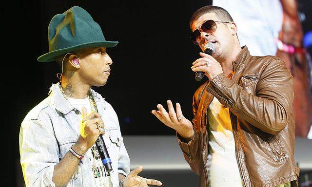 Singer Pharrell Williams and singer Robin Thicke perform together at the Walmart annual shareholders meeting in Fayetteville