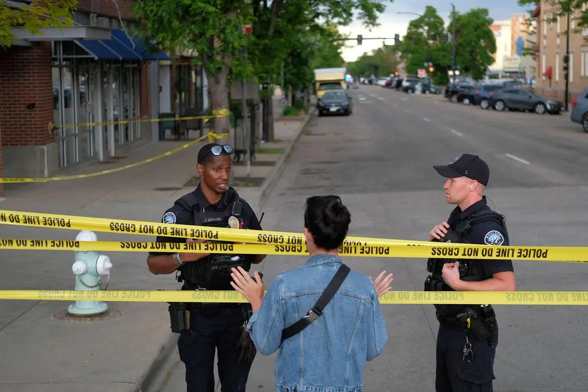 Police officers talk to a passerby at the scene of the attack