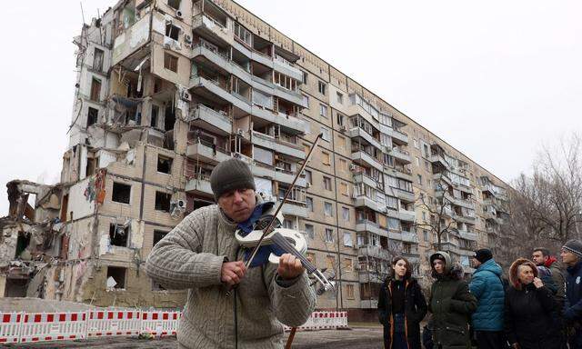 Gedenken an die Opfer: Nachbarn versammelten sich vor einem zerbombten Wohnhaus in der Stadt Dnipro. 