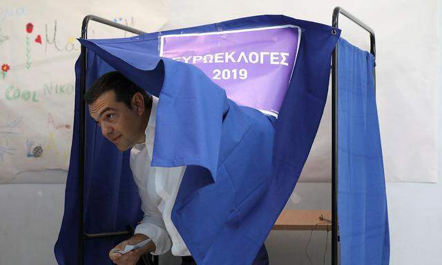 Greek PM Tsipras exits the polling booth before voting for the European and local elections at a polling station in Athens
