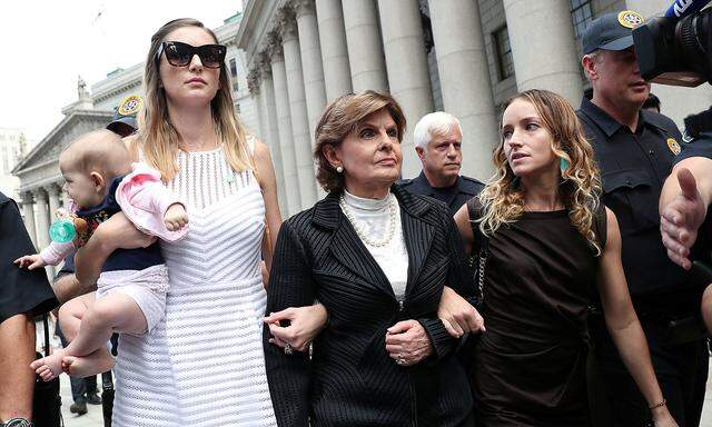 Allred, representing alleged victims of Epstein, leaves with Davies and an unidentified women and baby after the hearing in the criminal case in New York