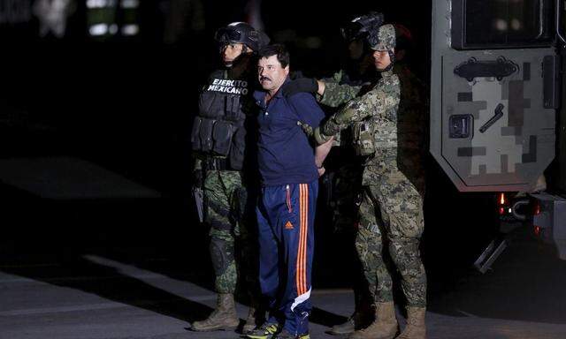 Recaptured drug lord Joaquin 'El Chapo' Guzman is escorted by soldiers during a presentation in Mexico City